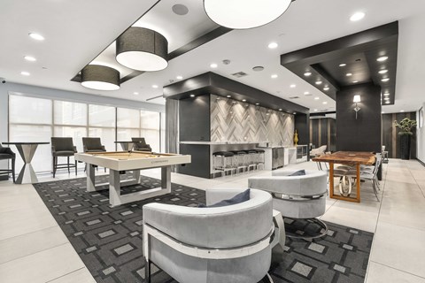 A modern living room with a pool table and comfortable seating.